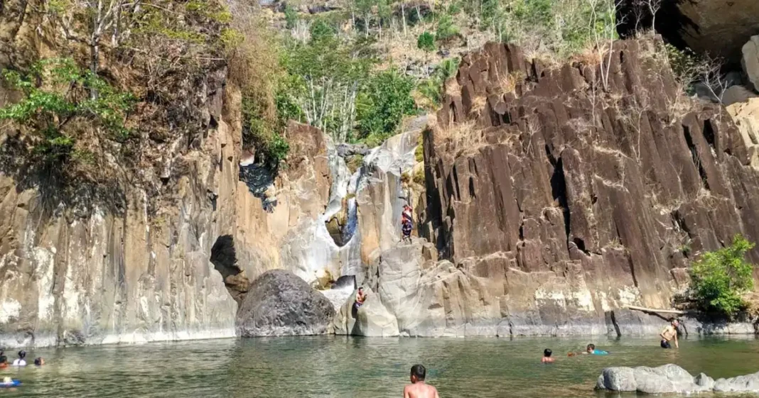 air terjun jurug waru dengan tebing karst dan telaga hijau di trenggalek