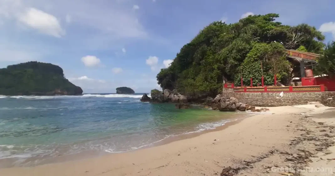 pemandangan pantai goa cina malang dengan tebing dan ombak eksotis